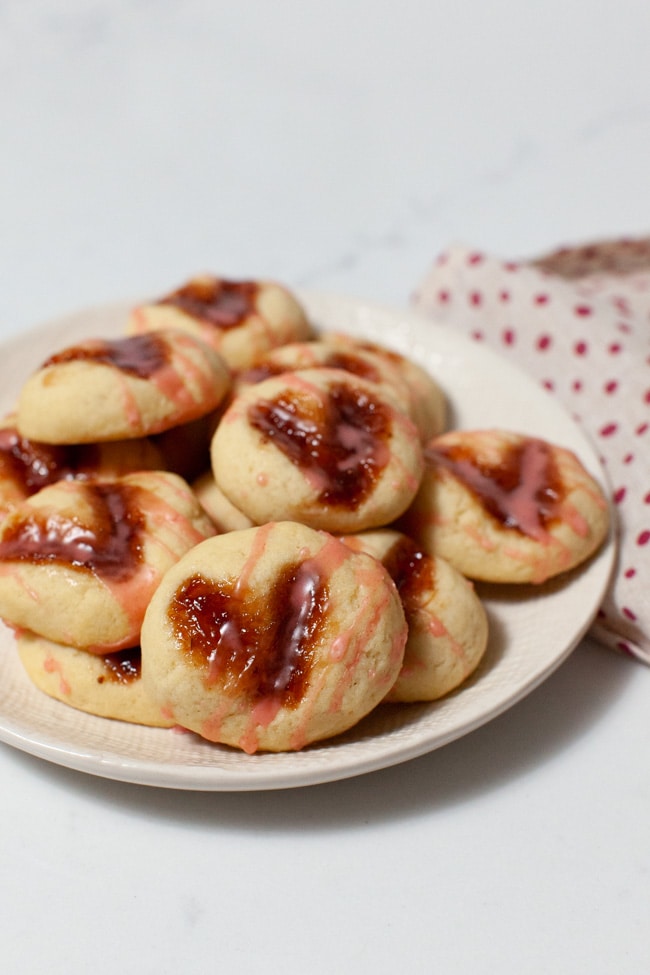 Heart-Shaped Thumbprint Cookies from thelittlekitchen.net heart shaped thumbprint cookies on a plate with a napkin in the background