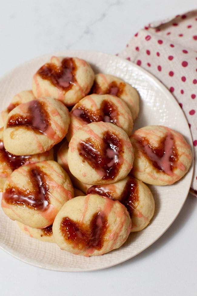 Heart-Shaped Thumbprint Cookies from thelittlekitchen.net heart shaped thumbprint cookies on a plate with a napkin in the background
