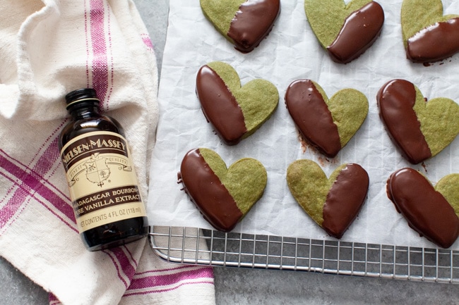 Matcha Cookies from thelittlekitchen.net Heart Shaped Chocolate Dipped Matcha Cookies on cooling rack next to bottle of vanilla extract from thelittlekitchen.net