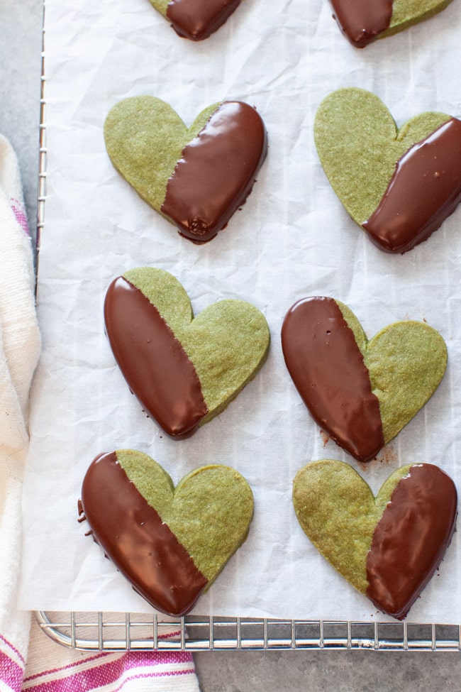 Matcha Cookies from thelittlekitchen.net Heart Shaped Matcha Cookies Dipped in Chocolate on White Parchment Paper from thelittlekitchen.net