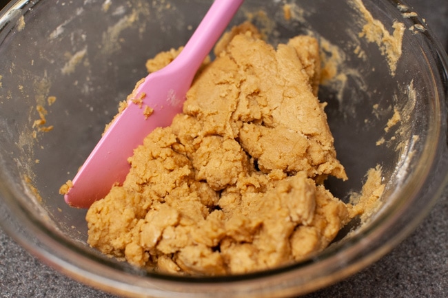 Peanut Butter Blossom Cookies from thelittlekitchen.net Peanut Butter Blossom Cookie dough a glass bowl with a pink rubber spatula.