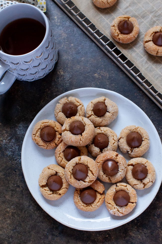 Peanut Butter Blossom Cookies from thelittlekitchen.net Peanut Butter Blossoms on a white plate next to a cup of coffee.