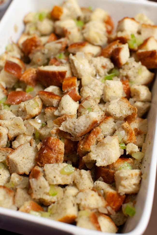 stuffing in a white baking dish before it goes into the oven